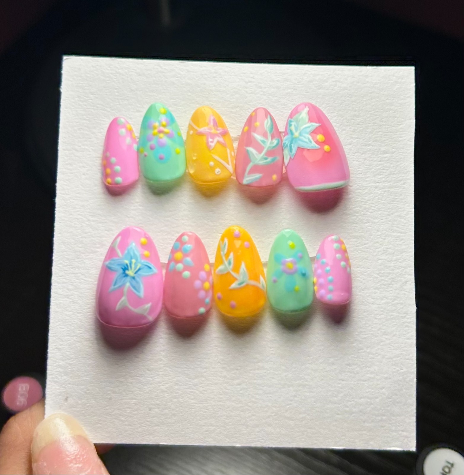 Multi-colored floral nail art with blue flowers and leaves with pink and yellow.