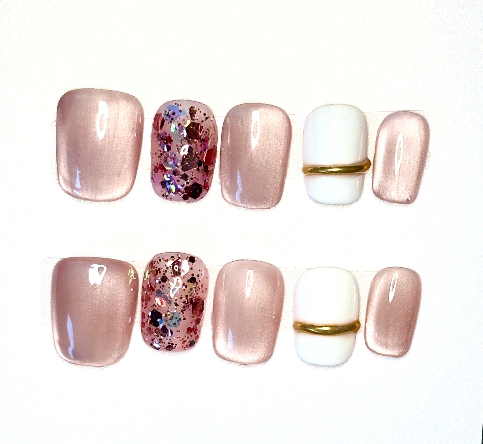 Elegant short round press-on nails featuring a soft rose gold metallic sheen, so