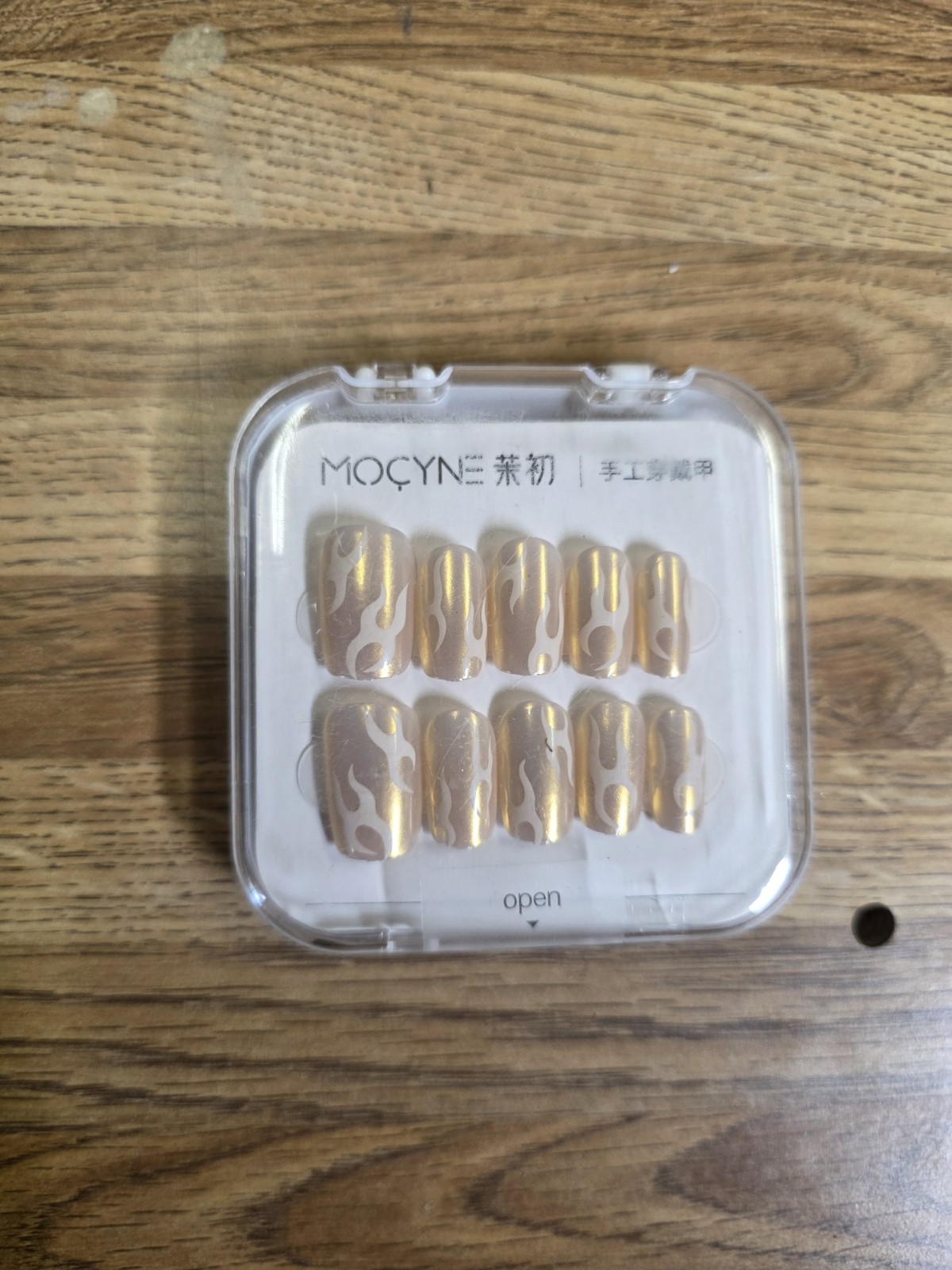 These are MOCYNE brand press-on nails featuring a nude base with metallic.