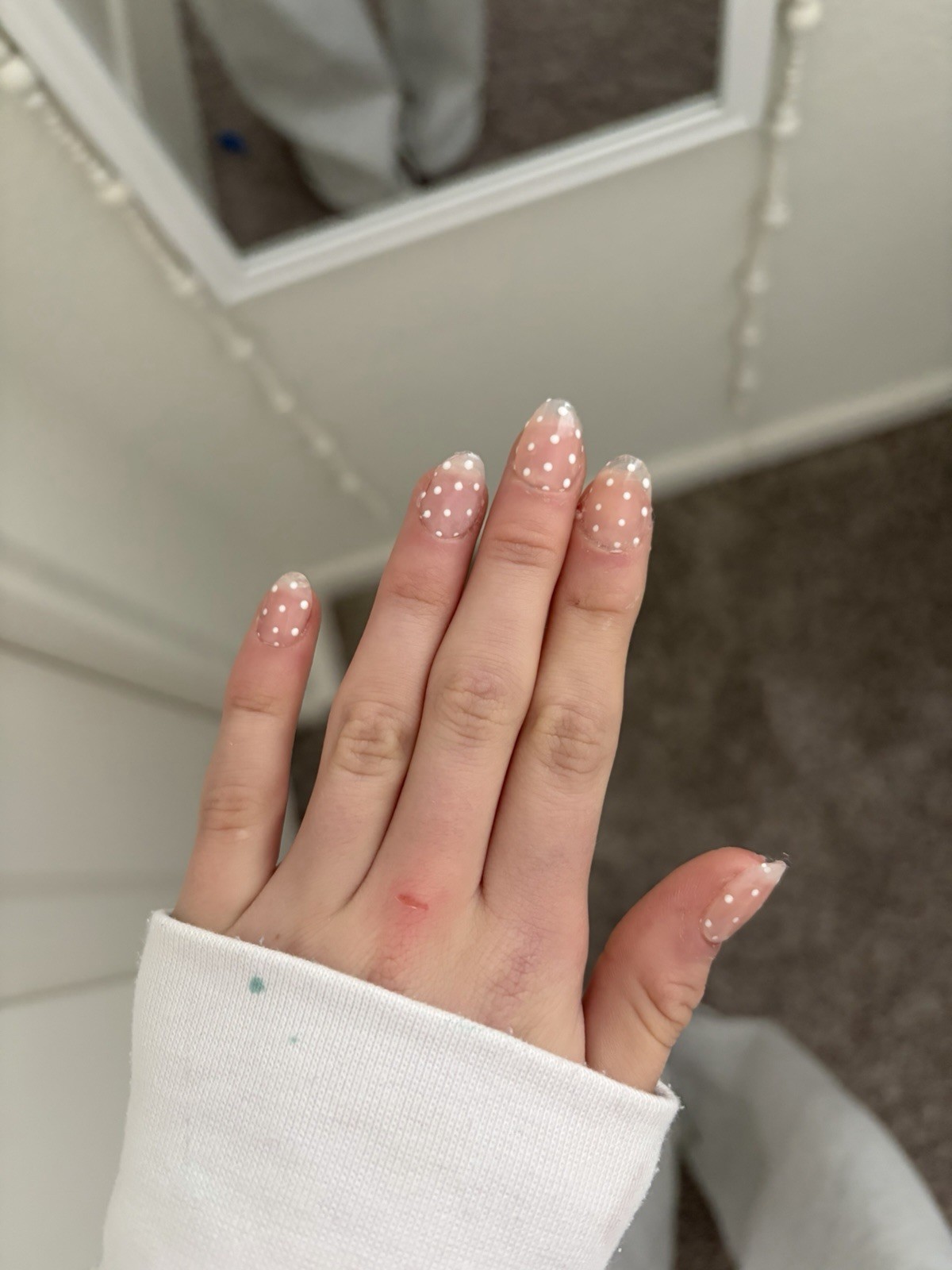 nude nails with white polka dots